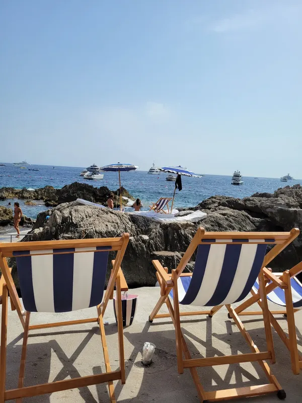 La Fontelina Capri beach club Faraglioni rocks VIP crowd fresh seafood Mediterranean summer dining