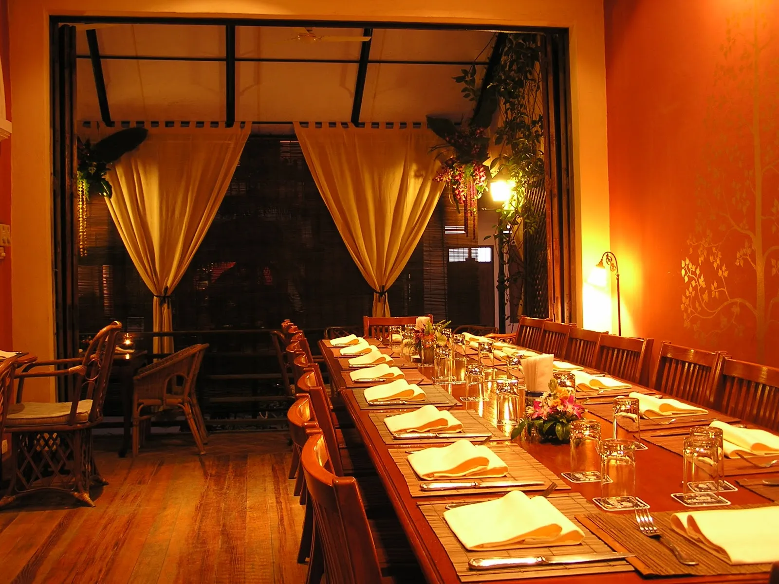 The colonial dining room of L'Elephant in Luang Prabang with shuttered windows and terrace seating