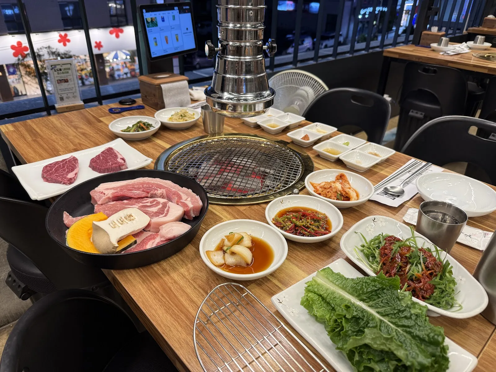 Charcoal-grilled Jeju black pork being cooked tableside at Namyeongdon