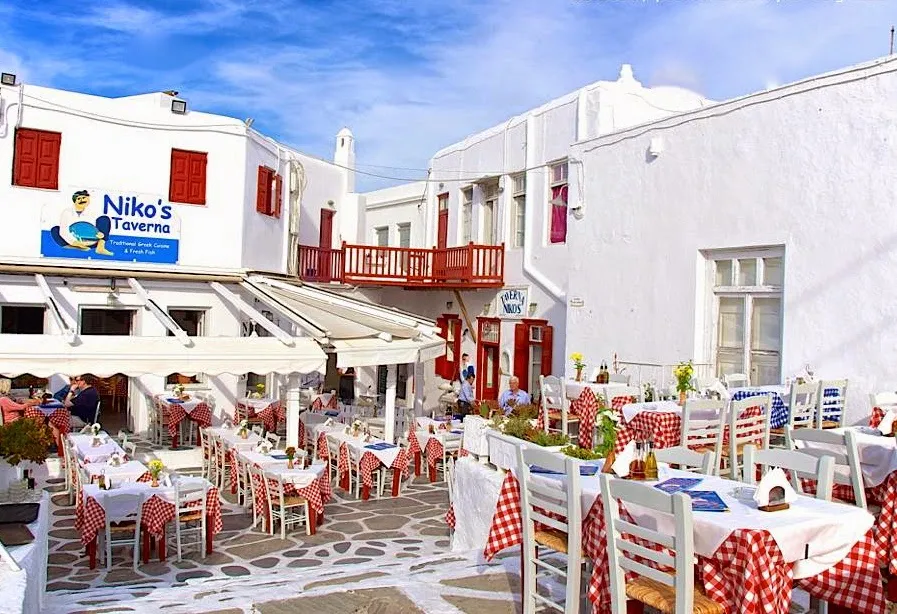 A single place setting at a whitewashed Mykonos taverna table
